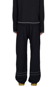 Wide running pants in Black with a soft stretch, two front pockets and a smart hidden pocket to keep your phone in place. Two reflective contrast seams around the bottom of each leg. Elasticated waist and hem with cord stoppers. Made in Econyl.