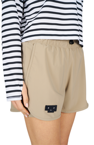 Women's running shorts in Warm Sand, featuring an inner lining and side vents. The 3-inch Flow Shorts offer a soft stretch and are made from ECONYL®. Podium Logo on the front and a reflective "Finish in a Good Place" slogan on the back. Includes one pocket in the inner lining and a hidden pocket at the back. Also available in a 5-inch length.