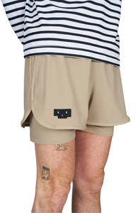 Running shorts in Warm Sand, featuring an inner lining and side vents. The 3-inch Flow Shorts offer a soft stretch and are made from ECONYL®. Podium Logo on the front and a reflective "Finish in a Good Place" slogan on the back. Includes one pocket in the inner lining and a hidden pocket at the back. Also available in a 5-inch length.