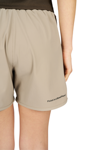 Women's running shorts in Warm Sand, featuring an inner lining and side vents. The 5-inch Flow Shorts offer a soft stretch and are made from ECONYL®. Podium Logo on the front and a reflective "Finish in a Good Place" slogan on the back. Includes one pocket in the inner lining and a hidden pocket at the back. Also available in a 3-inch length.