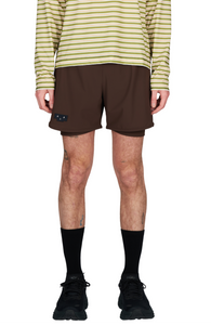 Running shorts in Red Brown, featuring an inner lining and side vents. The 5-inch Flow Shorts offer a soft stretch and are made from ECONYL®. Podium Logo on the front and a reflective "Finish in a Good Place" slogan on the back. Includes one pocket in the inner lining and a hidden pocket at the back. Also available in a 3-inch length.