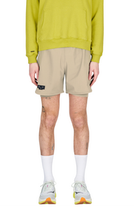 Running shorts in Warm Sand, featuring an inner lining and side vents. The 5-inch Flow Shorts offer a soft stretch and are made from ECONYL®. Podium Logo on the front and a reflective "Finish in a Good Place" slogan on the back. Includes one pocket in the inner lining and a hidden pocket at the back. Also available in a 3-inch length.