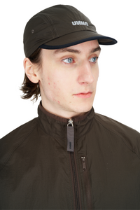 Unisex running cap in Wren Brown. Made in a lightweight (50g/m2) GRS Recycled Polyester. Water repellent, PFC free and adjustable strap. UNNA logo in front and black "Finish in a Good Place" patch in the back.