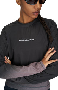 Women's long sleeve Running T-Shirt in Black/Grey with raglan sleeves. It features a gradient sublimation print shifting to a lighter shade at the bottom. Made from quick-drying, post-consumer recycled polyester with 4-way stretch for great flexibility, ventilation, and breathability. The UNNA "Finish in a Good Place" manifesto is printed on the chest.