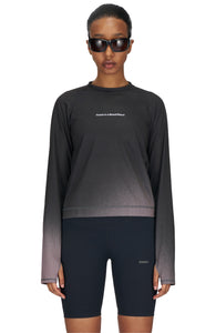 Women's long sleeve Running T-Shirt in Black/Grey with raglan sleeves. It features a gradient sublimation print shifting to a lighter shade at the bottom. Made from quick-drying, post-consumer recycled polyester with 4-way stretch for great flexibility, ventilation, and breathability. The UNNA "Finish in a Good Place" manifesto is printed on the chest.