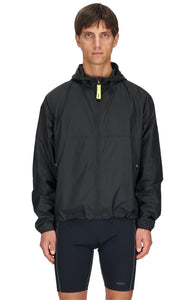 Men's ultra-lightweight running jacket (55g/m²) in Black. It features an adjustable hood, two side pockets, a back pocket, and side vents for enhanced ventilation. It is equipped with adjustable straps at the hem for a customizable fit. Made from 100% recycled nylon, it offers protection against wind and light rain. Additionally, it is packable, PFC-free, and features a reflective UNNA logo on the back, along with a UNNA patch on the zipper