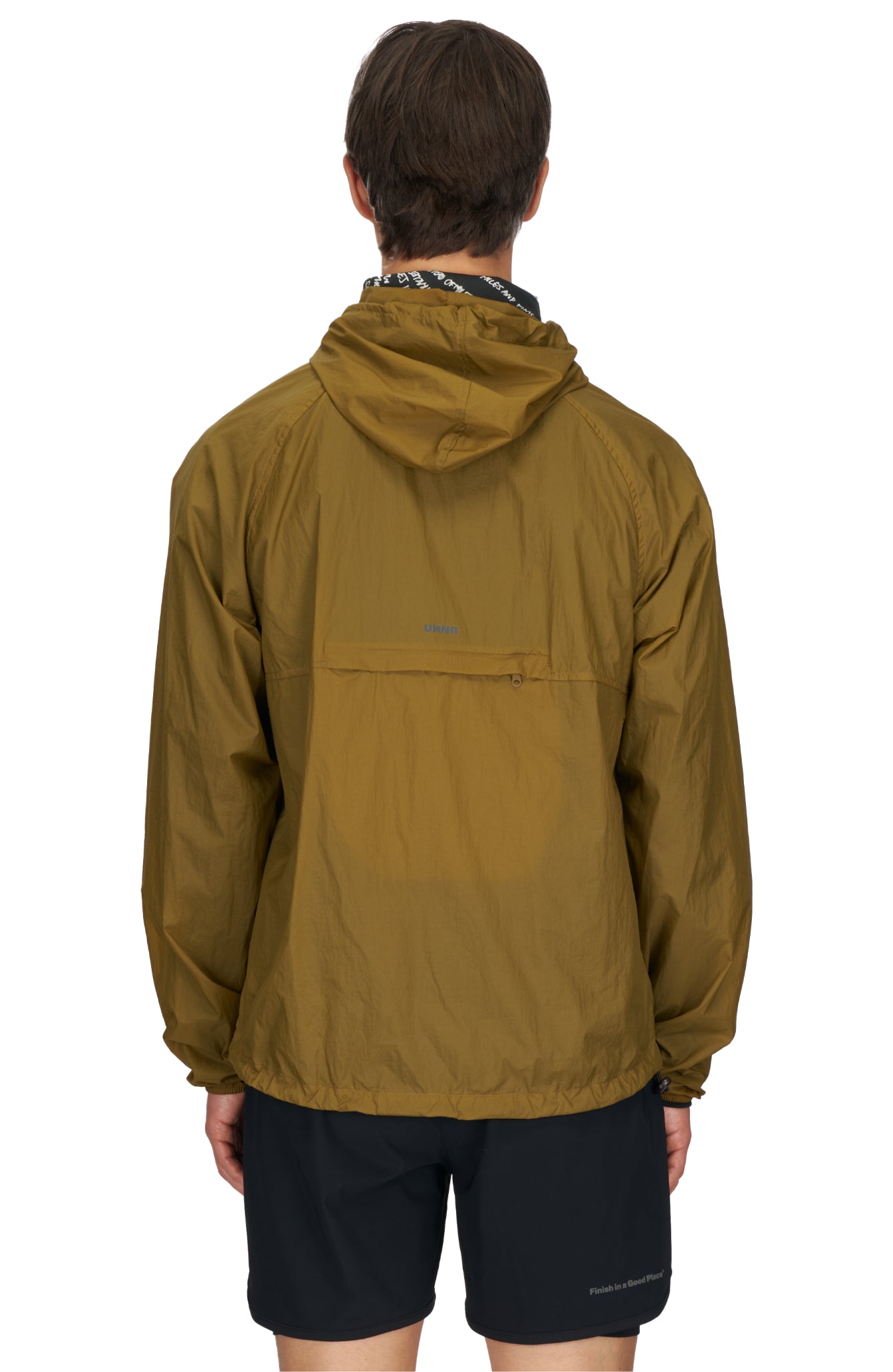 Men's ultra-lightweight running jacket (55g/m²) in Gold Olive. It features an adjustable hood, two side pockets, a back pocket, and side vents for enhanced ventilation. It is equipped with adjustable straps at the hem for a customizable fit. Made from 100% recycled nylon, it offers protection against wind and light rain. Additionally, it is packable, PFC-free, and features a reflective UNNA logo on the back, along with a UNNA patch on the zipper