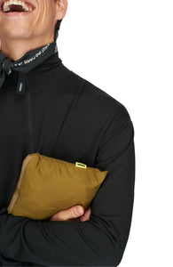 Men's ultra-lightweight running jacket (55g/m²) in Gold Olive. It features an adjustable hood, two side pockets, a back pocket, and side vents for enhanced ventilation. It is equipped with adjustable straps at the hem for a customizable fit. Made from 100% recycled nylon, it offers protection against wind and light rain. Additionally, it is packable, PFC-free, and features a reflective UNNA logo on the back, along with a UNNA patch on the zipper