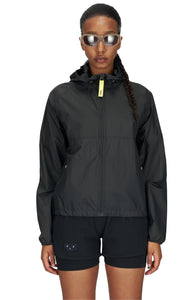 Women's ultra-lightweight running jacket (55g/m²) in Black. It features an adjustable hood, two side pockets, a back pocket, and side vents for enhanced ventilation. It is equipped with adjustable straps at the hem for a customizable fit. Made from 100% recycled nylon, it offers protection against wind and light rain. Additionally, it is packable, PFC-free, and features a reflective UNNA logo on the back, along with a UNNA patch on the zipper