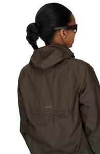 Women's ultra-lightweight running jacket (55g/m²) in Wren Brown. It features an adjustable hood, two side pockets, a back pocket, and side vents for enhanced ventilation. It is equipped with adjustable straps at the hem for a customizable fit. Made from 100% recycled nylon, it offers protection against wind and light rain. Additionally, it is packable, PFC-free, and features a reflective UNNA logo on the back, along with a UNNA patch on the zipper