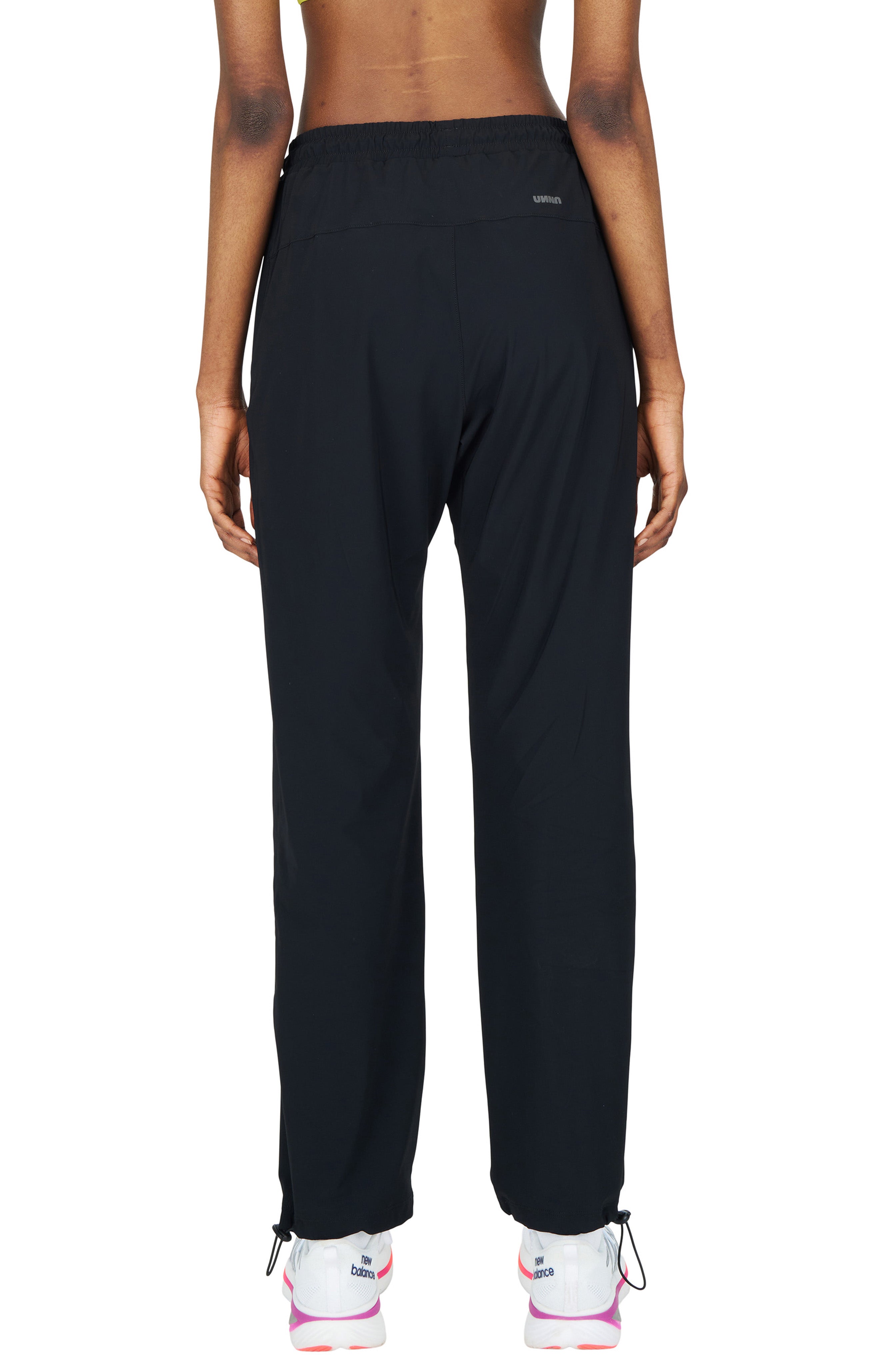 UNNA black running pants for women with a soft stretch and two front pockets.